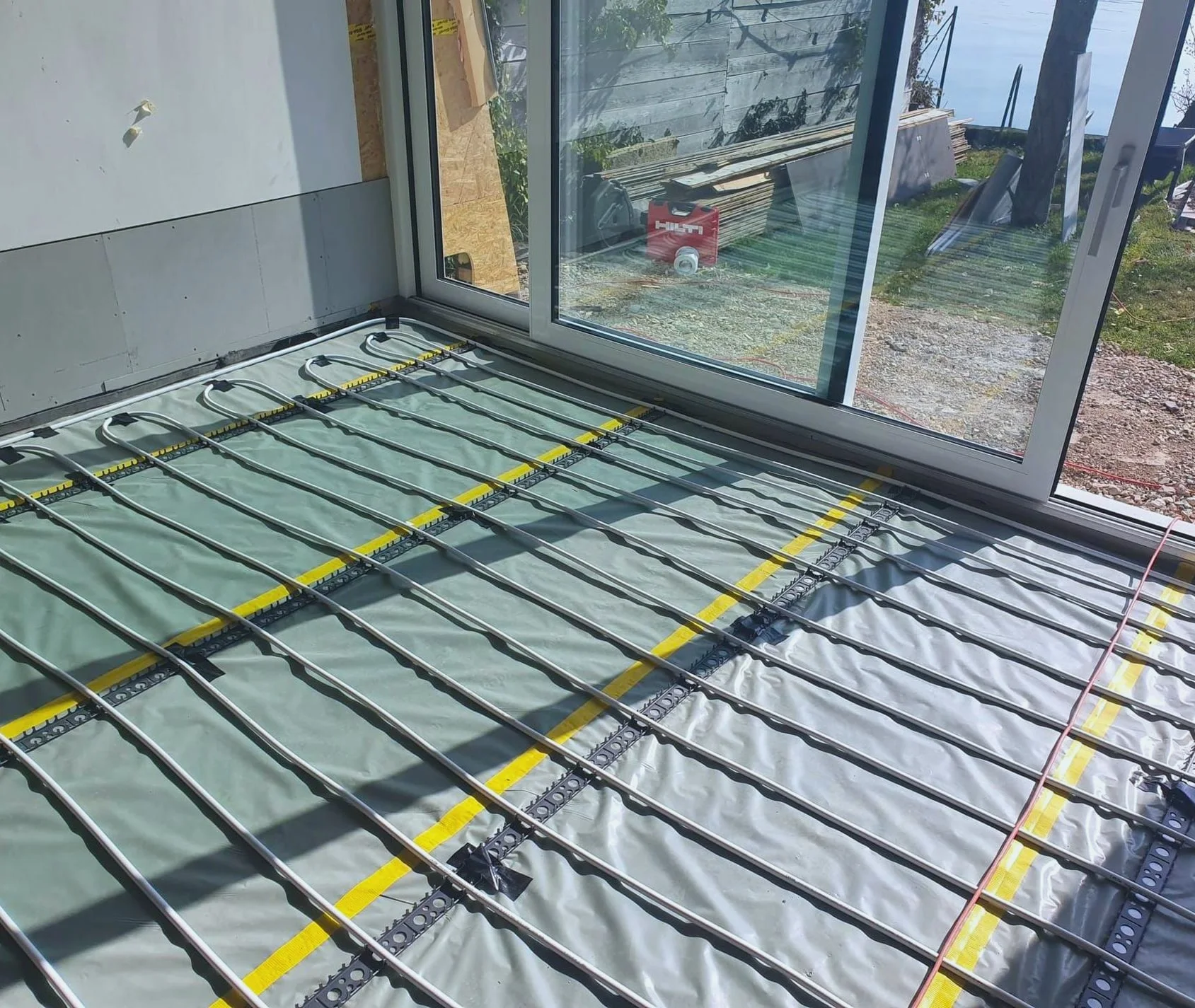 Vorbereitete Fussbodenheizung in einem Neubau mit Blick ins Freie.