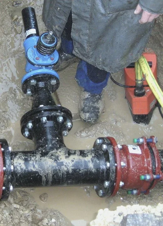 Abzweigung und Anschlussstück einer Wasserleitung im Erdreich.